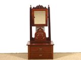 une petite commode en bois surmontée d'un miroir