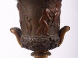 a bronze vase with a man and a woman on it