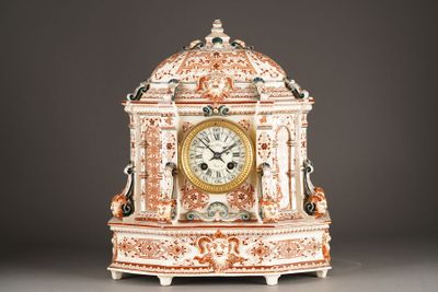 a white and orange clock sitting on a table