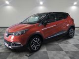 une voiture rouge est garée dans une pièce au sol en damier