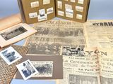 several old newspapers and old photographs are on display on a table