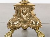 a gold vase on a stand with a flower in it