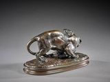 a bronze statue of a lion on a wooden base