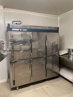 un grand réfrigérateur en acier inoxydable dans une cuisine professionnelle