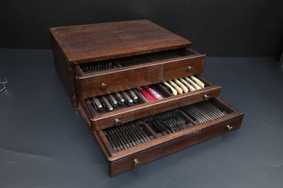 a wooden box with knives and spoons in it