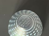 a silver bowl with white dots on it sitting on a table