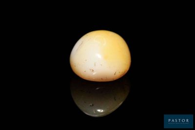 a white egg sitting on top of a black surface