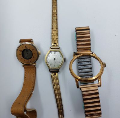 Trois montres sont posées les unes à côté des autres sur une table.