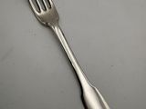 a silver fork on a table with a white background