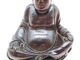 figurine de Bouddha assis en position de méditation sur un fond blanc