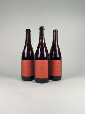 three bottles of wine sitting on top of a white surface