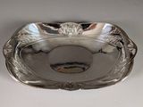a silver plate with a fish in it on a table
