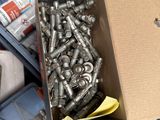 a box full of screws and nuts sitting on the floor
