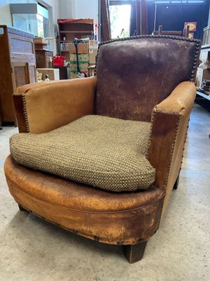 a brown chair with a cushion on it in a room