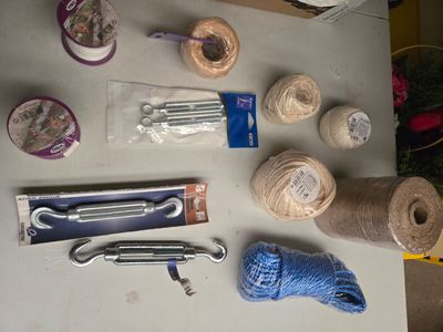 une table sur laquelle sont posés du fil, des ciseaux et d'autres objets