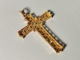 a gold cross that is on a white surface