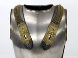a silver and gold armor on display on a table