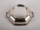 a silver plate with a ring on it on a white surface