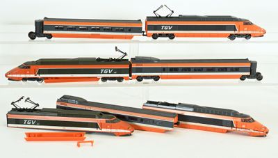 quatre vues différentes d'un train miniature exposé sur une surface blanche