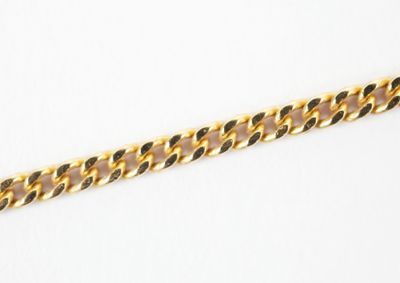a close up of a gold chain on a white surface