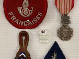 trois médailles et une médaille sont exposées sur un support blanc