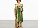the statue of a man in a green robe and hat is holding a cane
