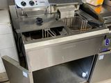 plan de travail en acier inoxydable équipé de deux friteuses dans une cuisine professionnelle