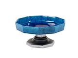 un petit bol bleu posé sur un socle, sur fond blanc