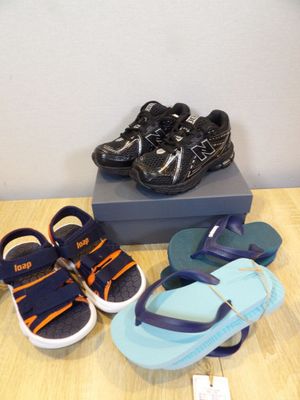 several pairs of children ' s shoes are on a table next to a box