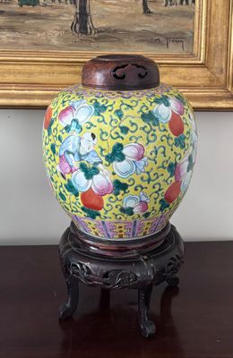 un vase posé sur une table devant un tableau