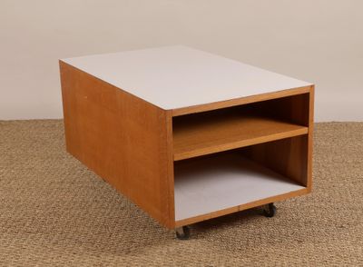 une petite table en bois avec un plateau blanc, montée sur roulettes