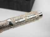 a silver pen that is sitting on top of a table