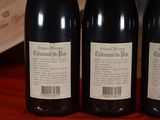 three bottles of wine sitting on a table with a wooden box in the background