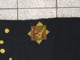 a picture of a black and yellow rug with a yellow star on it