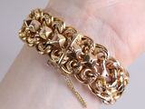 gold bracelet with a lion head and a chain on a woman ' s wrist