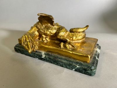 une figurine en or posée sur un socle en marbre