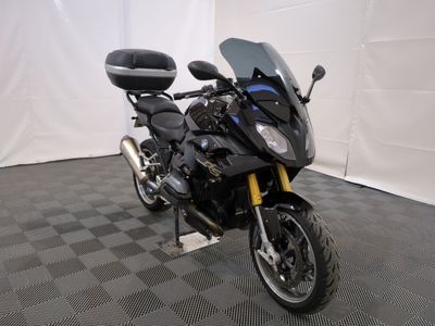 a black motorcycle parked in a room with a checkered floor