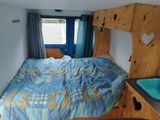 a bed with a blue comforter in a small room