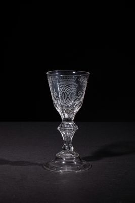 an empty wine glass sitting on a table with a black background