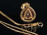 an image of a gold necklace with a pink stone pendant