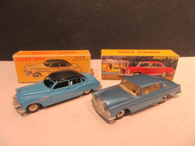 Deux petites voitures sont assises l'une à côté de l'autre sur une table.