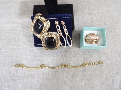 un ensemble de bijoux noirs et dorés posé sur une table