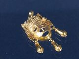 un pendentif en or orné d'une couronne, sur un fond bleu