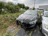 Deux voitures sont garées sur le bord d'une route, près d'une maison.