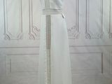 a dress on a mannequin stand in front of a wall