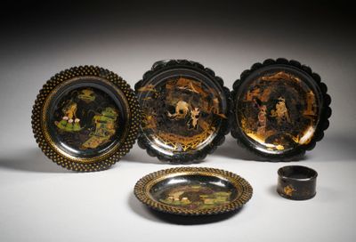quatre assiettes décorées de noir et d'or et un petit bol