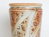 a brown and white vase sitting on a table