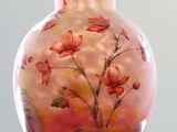 a glass vase with flowers painted on it sitting on a table