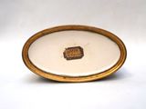 a white plate with a gold rim and a picture of a castle on it