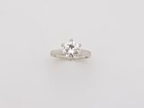 a single stone diamond ring on a white background
